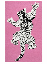 A rectangular pink rug featuring a large stylized black-and-white spotted animal silhouette centered on the surface.