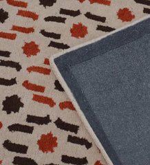 Beige wool rug with contemporary orange and brown dotted cascade