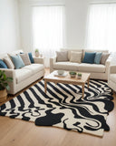 Beige and black melt wave hand-tufted area rug placed in a living room, featuring flowing abstract patterns that add a modern, stylish, and dynamic accent