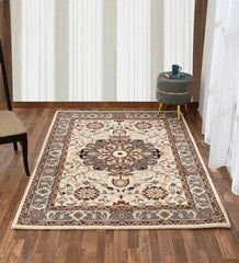 Beige and brown traditional ornate area rug on wooden floor with gray ottoman and chair
