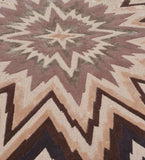 Beige and brown geometric starburst pattern rug with textured fabric detail