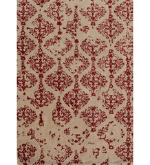 Beige rug with ornate red damask pattern featuring symmetrical floral and scroll motifs
