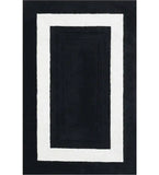 Black hand-tufted solid wool rug with white rectangular border, modern luxury design