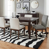 Black and ivory zebra pattern hand-tufted area rug styled in a dining room, adding a bold and modern statement