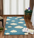 Blue hand-tufted wool rug with white cloud pattern on wooden floor in cozy room setup