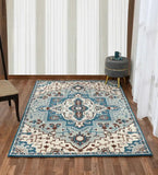 Blue and ivory traditional geometric floral rug on hardwood floor with gray ottoman and chair