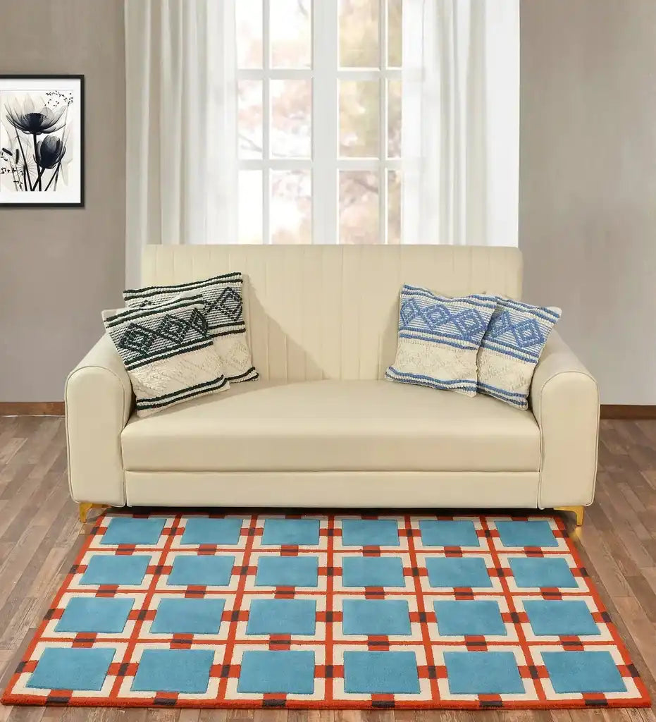 Blue and red retro geometric grid rug in a modern living room with beige sofa and window