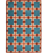 Hand-tufted wool rug with retro geometric grid pattern in teal blue, rust red, and ivory.