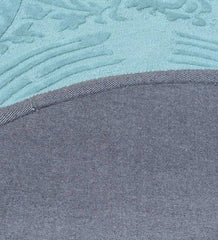 Close-up of a blue traditional hand-tufted round rug showing detailed textured patterns and fabric edge