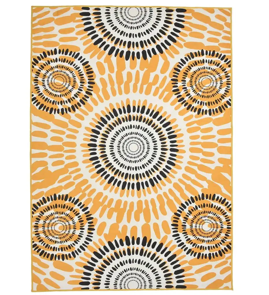 Boho sunburst rug with circular black and mustard yellow patterns on white background