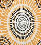 Close-up of boho sunburst rug with concentric circular patterns in black and mustard yellow on white