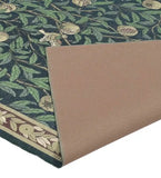 Luxury handwoven botanical rug with green leaves and pomegranate design, folded to show non-slip backing