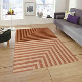 Modern living room with brown geometric striped rug, gray sofa, and light wood flooring