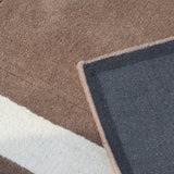 Close-up of a textured rug with geometric pattern in brown, white, and blue.