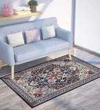 luxury vintage style burgundy and navy blue patterned rug on wood floor next to light blue sofa with cushions