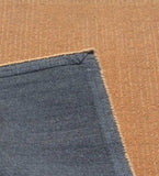 Minimalist hand-tufted wool rug in camel brown with edge detailing