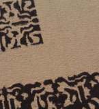 Close-up of camel color hand-tufted rug with black abstract floral pattern, luxury home decor