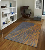 Charcoal gray and golden brown abstract area rug on wooden floor in modern living room