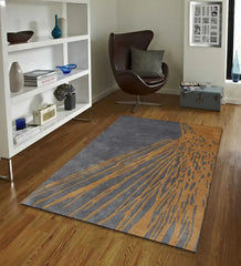 Charcoal gray and golden brown abstract area rug on wooden floor in modern living room