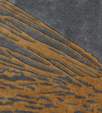 Abstract rug with charcoal gray background and golden brown irregular linear accents
