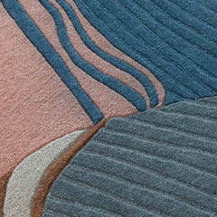 Close-up of a textured contemporary abstract thread design rug with blue, pink, gray, and brown colors