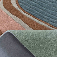 Close-up of contemporary abstract thread design rug with layered pink, brown, blue, and green shapes