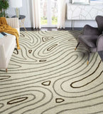 Modern living room with beige tufted rug featuring abstract organic patterns, cream sofa with mustard throw, and gray armchair