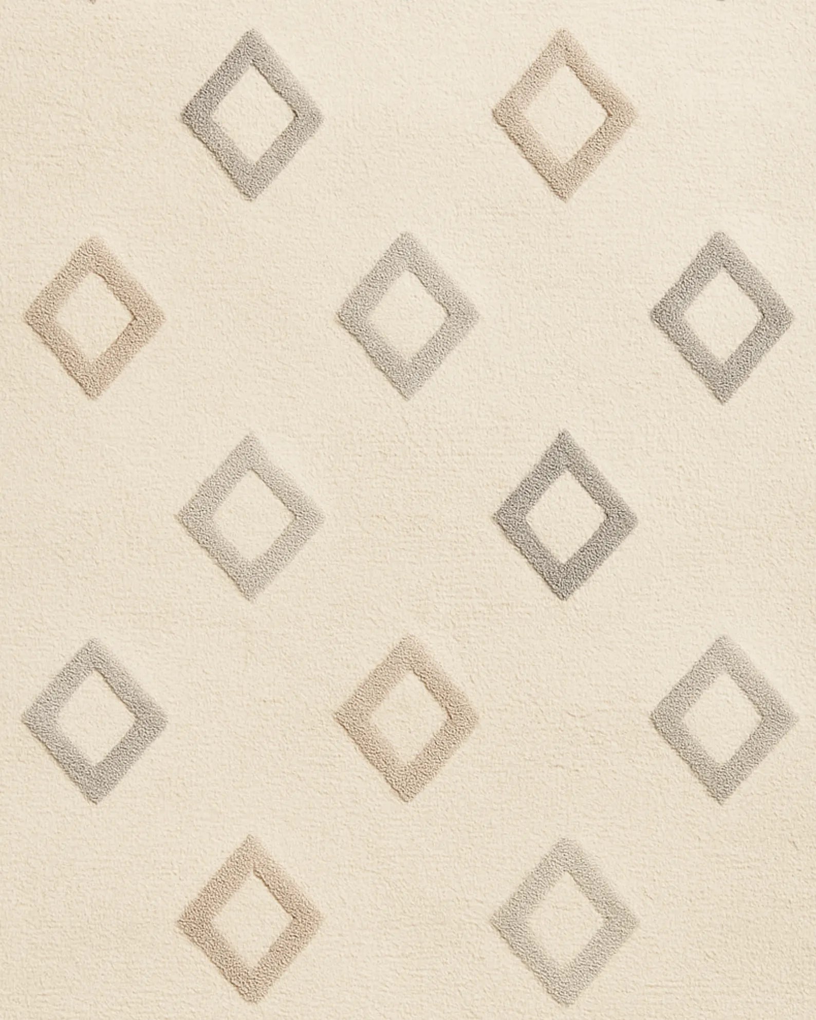 Hand-tufted wool rug in soft cream with subtle diamond texture.