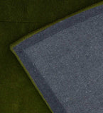 Handcrafted wool rug with subtle embossed border in green