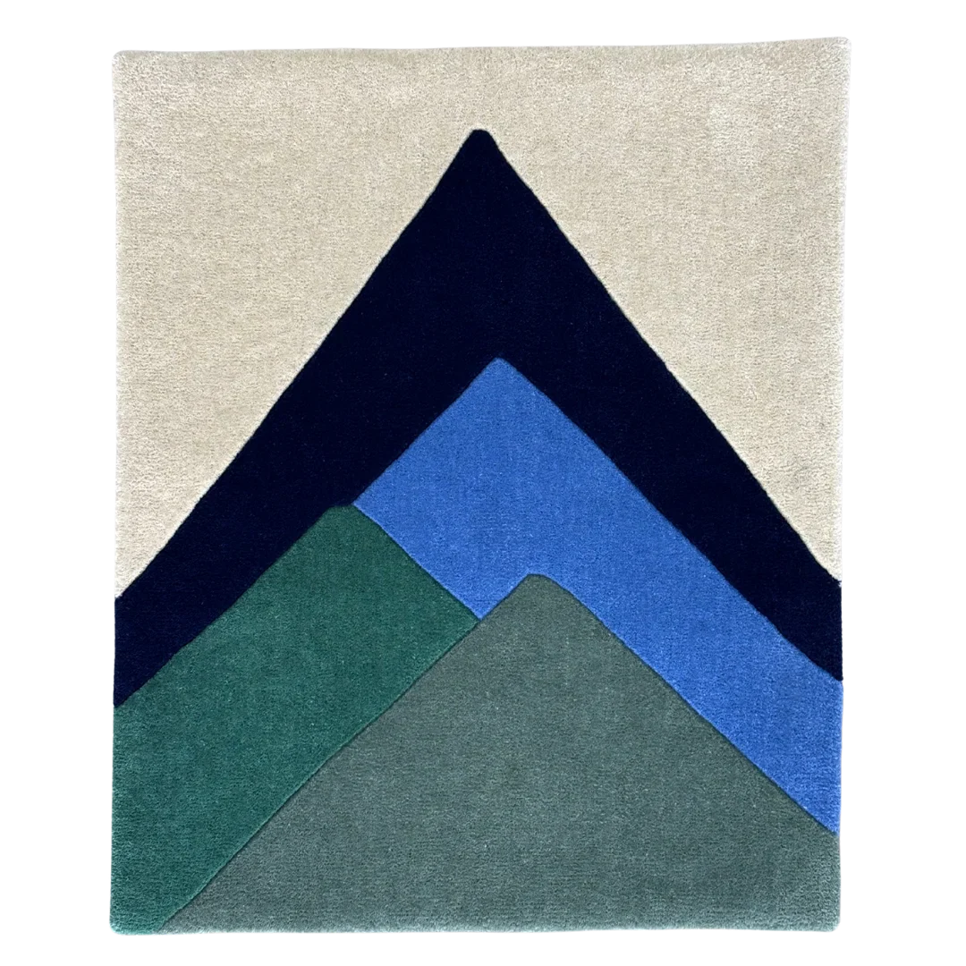 Rug with geometric mountain design in navy, blue, and green on a beige background