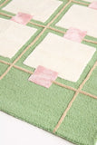 Handwoven luxury rug with green, white, and pink geometric square pattern from Mannat Rugs