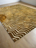 Golden brown modern abstract sunburst wave rug with white wavy lines on wooden floor