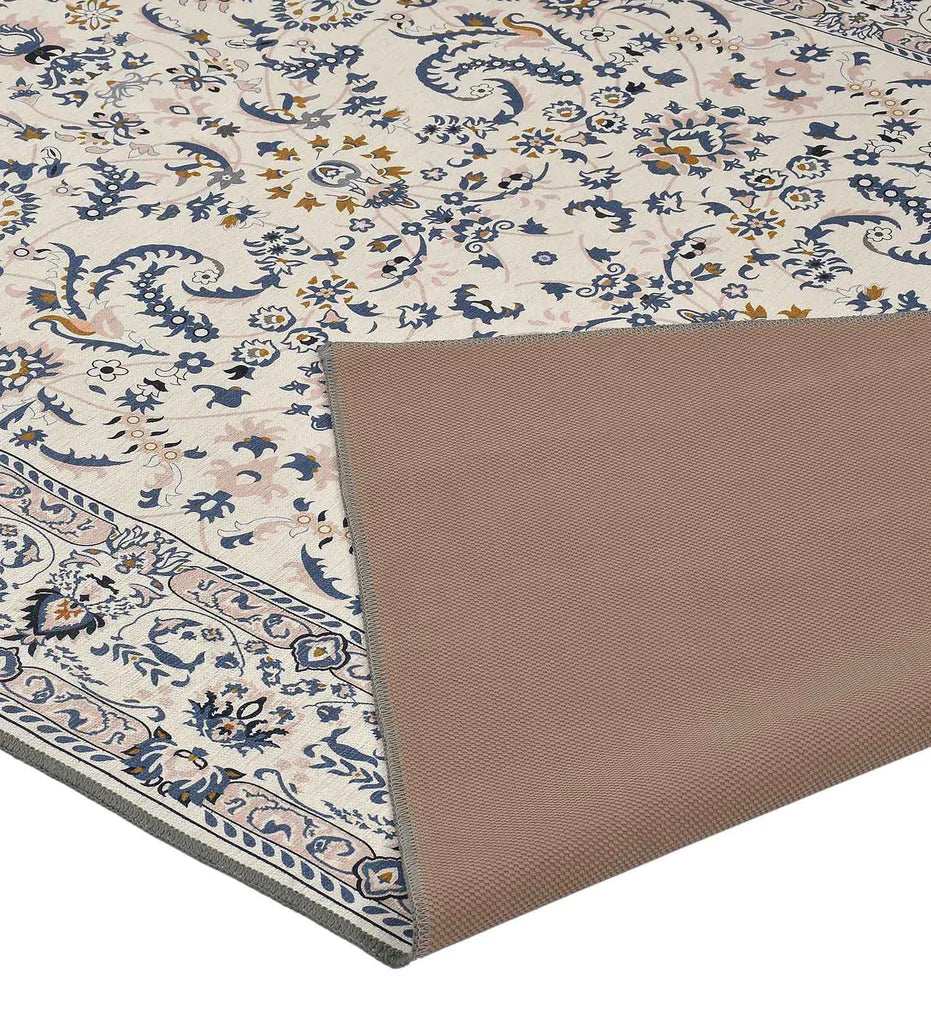 Gray medallion area rug with blue, gold, and ivory floral pattern, corner flipped