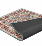 Light blue hand-tufted rug with intricate floral pattern and colorful border, corner flipped