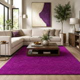 Living room with a purple rug, white sofa, and wooden coffee table.