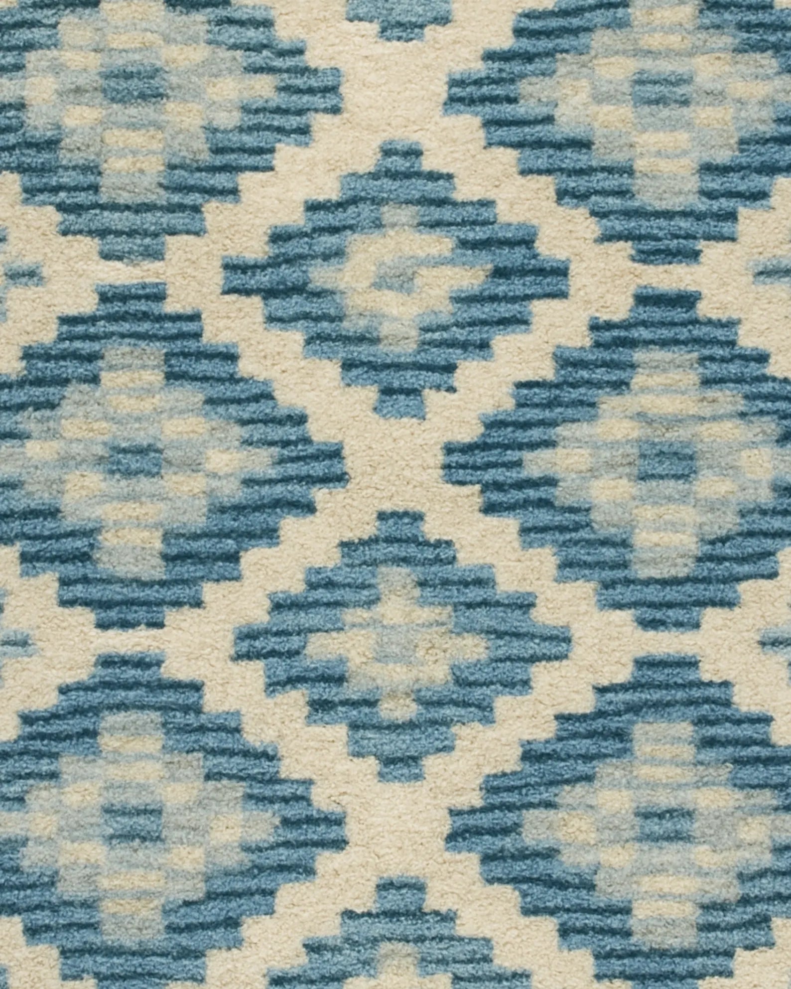 Handcrafted wool diamond rug in blue and ivory tones.