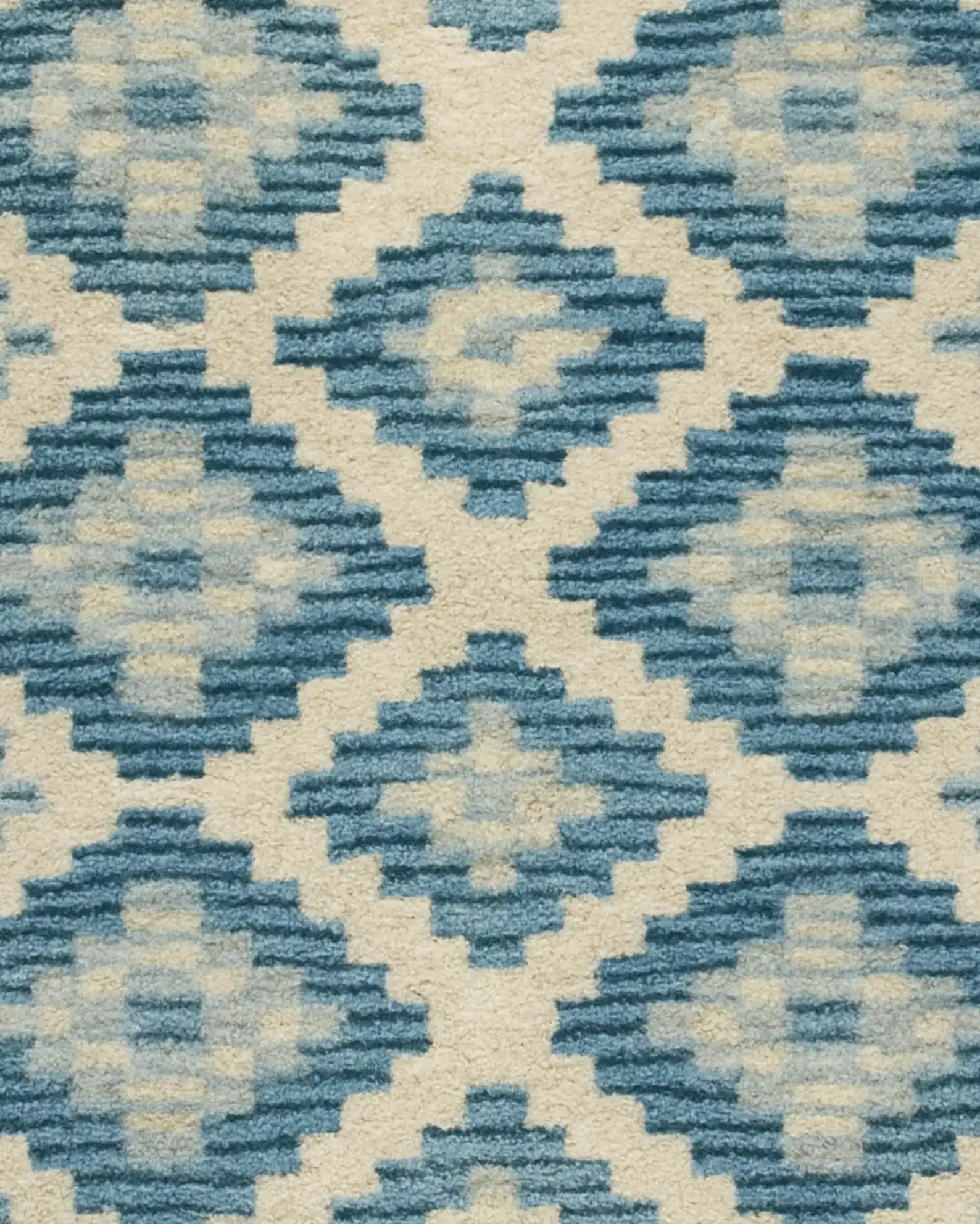 Handcrafted wool diamond rug in blue and ivory tones.