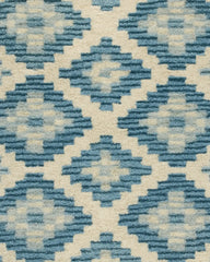 Handcrafted wool diamond rug in blue and ivory tones.
