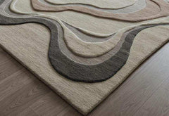 Luxury woolen hand-tufted beige rug with textured curved wave patterns on wooden floor