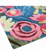 Close-up of a handwoven luxury rug with vibrant pink, blue, cream, and green floral patterns from Mannat Rugs