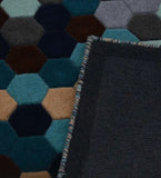 Modern geometric hexagon rug with blue, brown, teal, and beige gradient colors, close-up detail