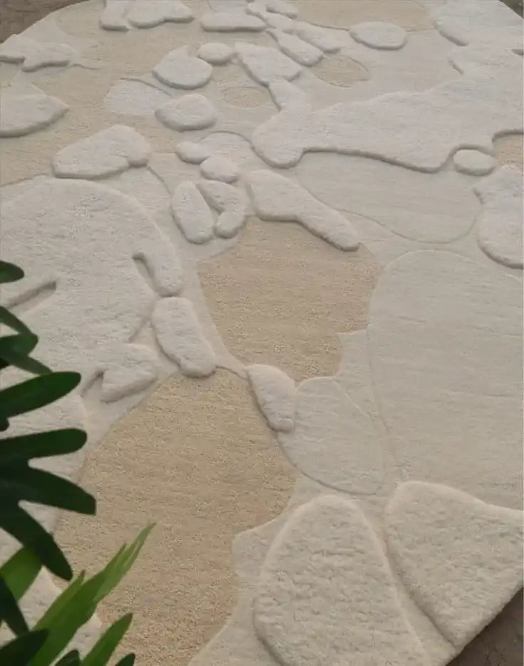 Modern neutral abstract organic rug with irregular cream and beige shapes, plant in corner