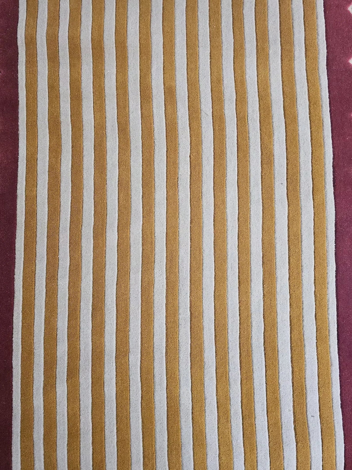 Striped fabric with brown and white stripes with a pink border