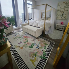 Luxury bedroom with white canopy bed, cream bench, and floral hand-tufted rug featuring colorful birds and black border