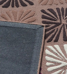 Close-up of multicolor floral block wool rug with beige, brown, and white flower patterns and denim-like backing