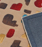 Multicolor modern abstract area rug with neutral beige base and geometric shapes in red, brown, yellow, and blue