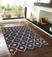 Navy blue modern geometric pattern area rug on dark hardwood floor by fireplace