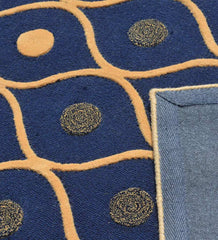 Navy blue rug with modern geometric orange lines and circular patterns, showing corner backing
