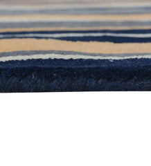 Soft wool hand-tufted rug with vertical pattern in navy, gray and peach hues.