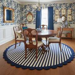 Round navy blue and ivory scalloped border hand tufted rug placed under a round table for coordinated decor